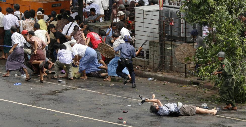 File photo of Nagai of APF trying to take photographs as he lies injured after police and military officials fired upon and then charged at protesters in Yangon's city centre