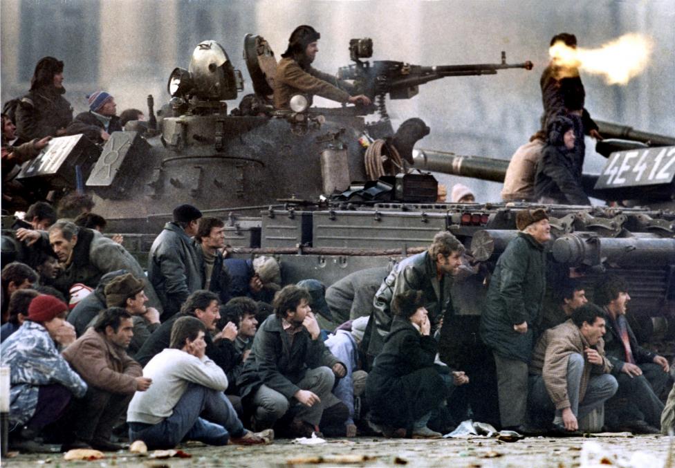 File photo of Bucharest's residents protecting themselves from the crossfire between an army tank and pro-Ceausescu troops during clashes in the Republican square in Bucharest