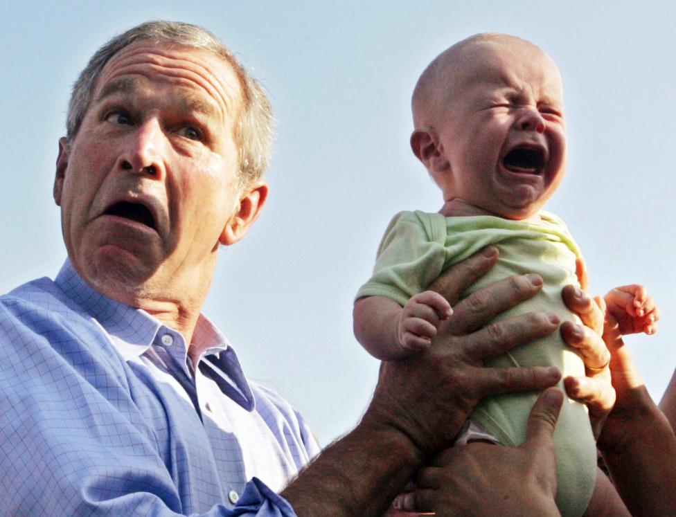 File photo of US President Bush handing back a crying baby that was handed to him in Trinwillershagen