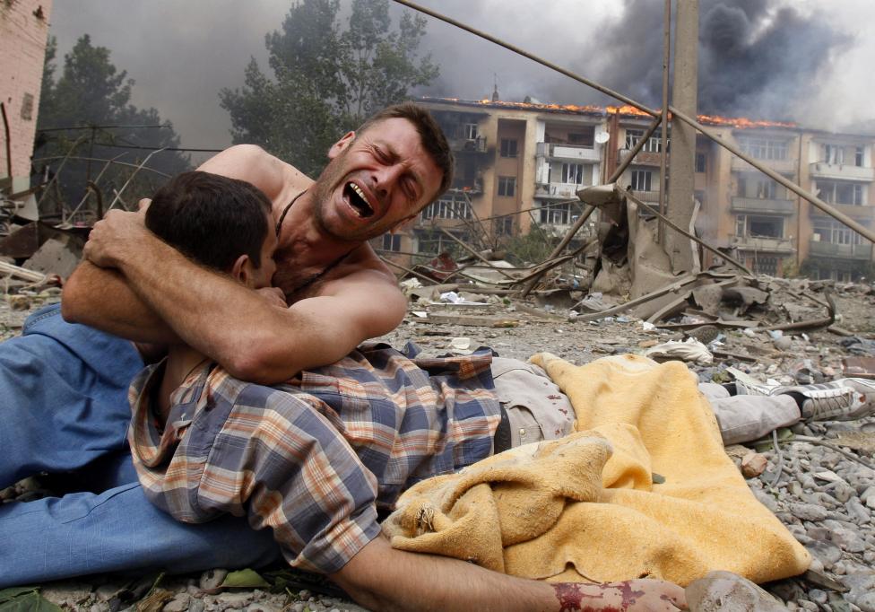 File photo of a Georgian man crying as he holds the body of his relative after a bombardment in Gori