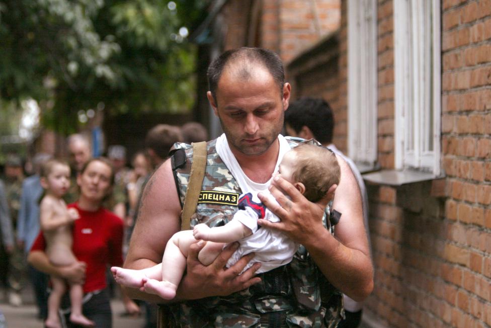 File photo of a Russian police officer carrying a released baby from Beslan school
