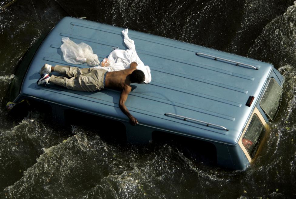 File photo of a man clinging to the top of a vehicle in the aftermath of Hurricane Katrina in New Orleans