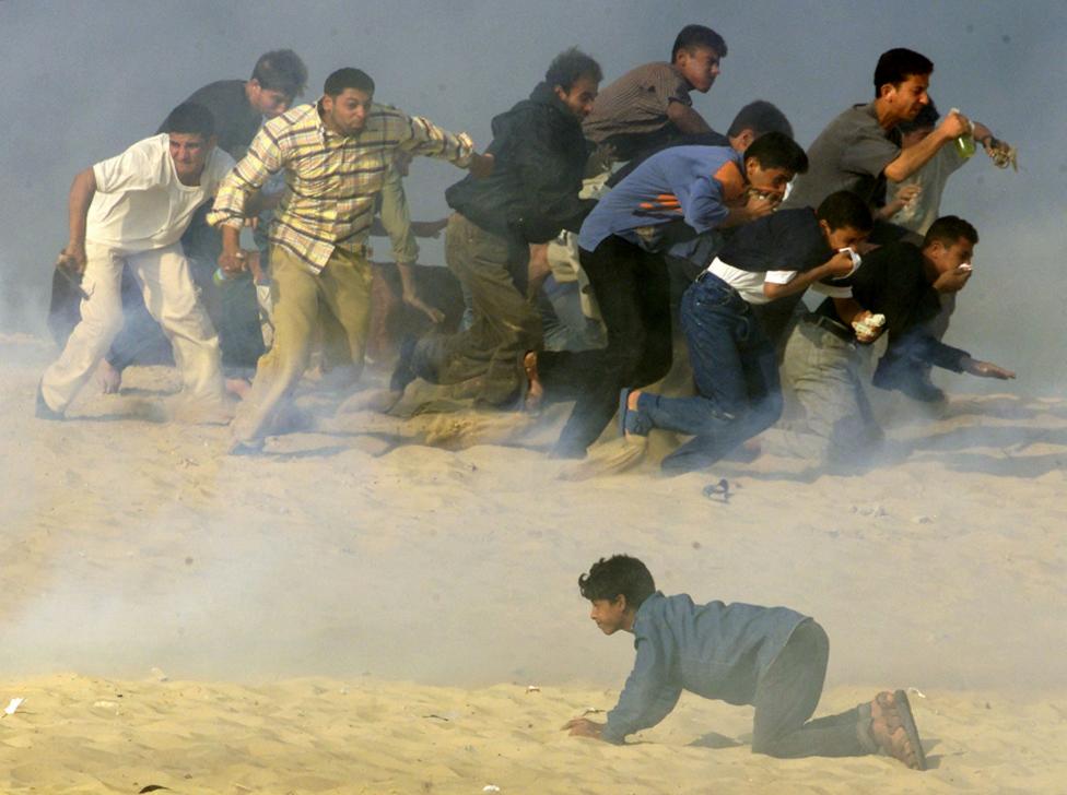 File photo of Palestinians trying to run away from Israeli soldiers firing teargas