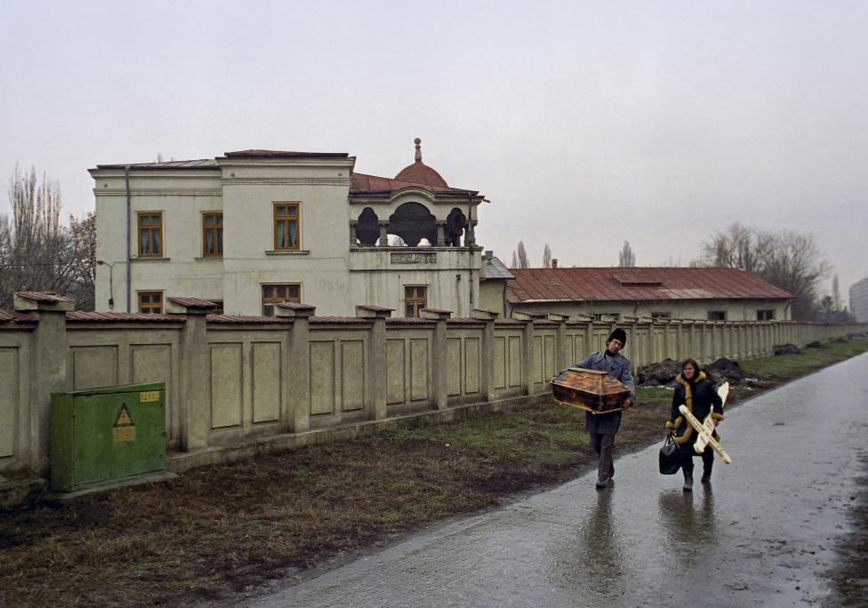 File photo of Romanian parents carrying a small casket and cross as they arrive at a Bucharest hospital to collect the body of their dead baby who died of AIDS