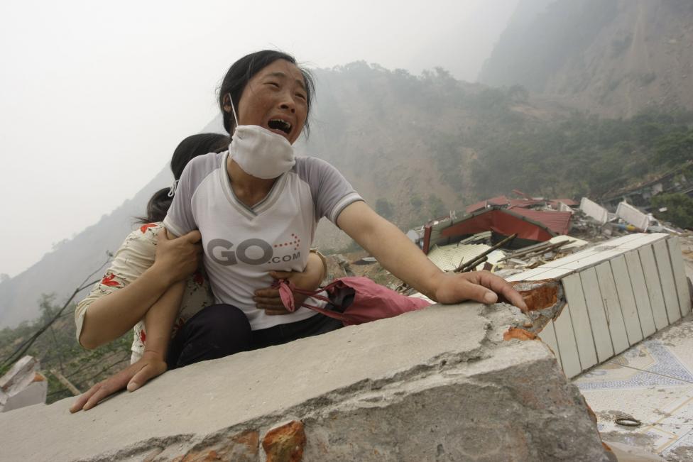 File photo of a woman crying as she cannot find her 4-year-old daughter and husband on the top of the ruins of a destroyed school in earthquake-hit Beichuan county