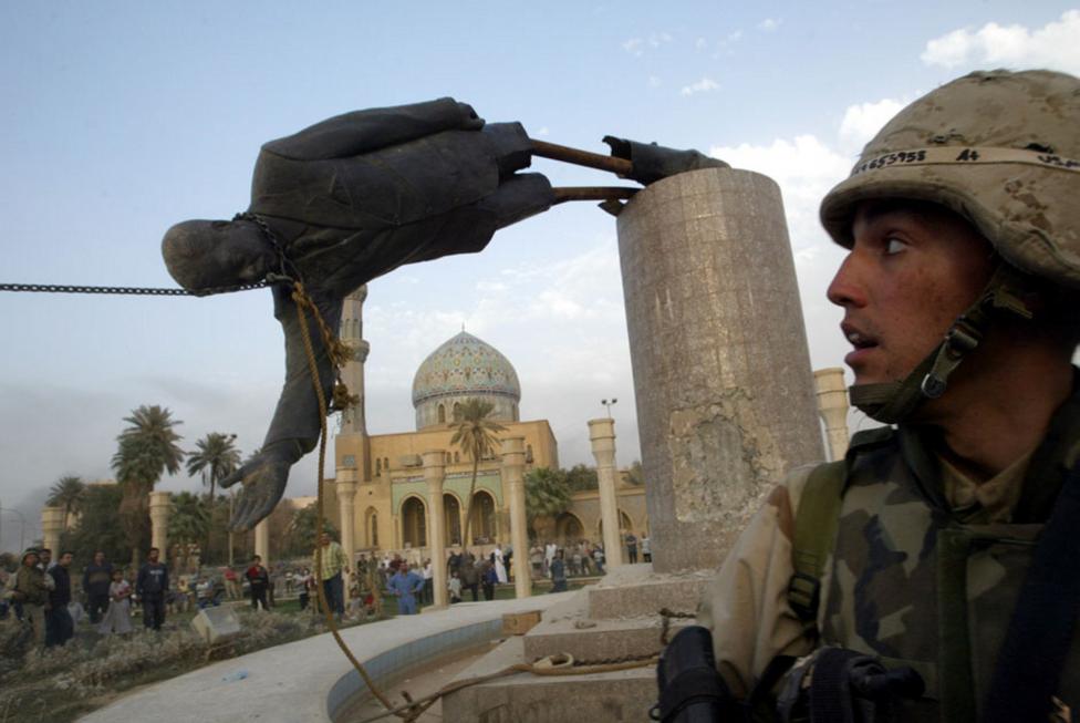 File photo of U.S. Marine Corp Assaultman Kirk Dalrymple watching as a statue of Iraq's President Saddam Hussein falls in central Baghdad