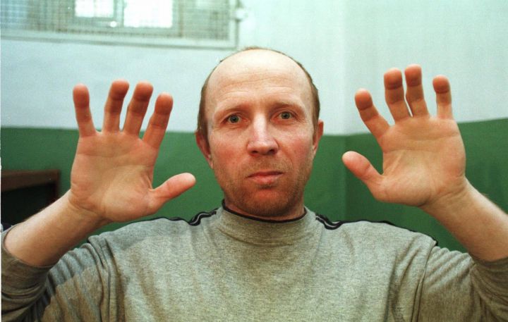 PHOTO MADE AVAILABLE WEDNESDAY, MARCH 31, 1999 Anatoliy Onoprienko , 39, shows his hands as he comments on the number of people he has killed, in his prison cell in Zhytomyr, Ukraine, Tuesday, March 30, 1999. The former sailor was declared guilty Wednesday in the worst killing spree in modern Ukrainian history, with a judge reading a lengthy verdict documenting 52 slayings. The detailed verdict took the whole court day to read, and sentencing for Onoprienko was not expected to be announced until Thursday. (AP Photo/Efrem Lukatsky)