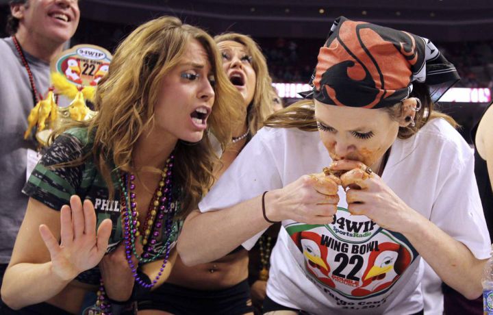 A wingette, left, cheers on contestant Molly Schuyler, of Omaha, Neb., during the Sportsradio 94 WIP's Wing Bowl 22 held at the Wells Fargo Center in Philadelphia, on Friday, Jan. 31, 2014. Molly went on to win the competition. (AP Photo/Philadelphia Daily News, Alejandro A. Alvarez)