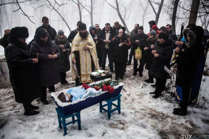 Mourners gather around a coffin bearing Artiam, 4, who was killed in a Ukrainian army artillery strike, during his funeral in Kuivisevsky district on the outskirts of Donetsk, eastern Ukraine, Tuesday, Jan. 20, 2015. At least three civilians were killed in shelling Tuesday in eastern Ukraine as fighting continued between government and rebel forces in the separatist-held city of Donetsk. (AP Photo/Manu Brabo)
