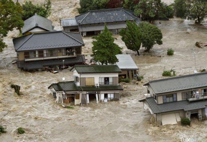 Residents are seen as they wait for rescue helicopters at a residential area flooded by the Kinugawa river, caused by typhoon Etau, in Joso, Ibaraki prefecture, Japan, in this photo taken by Kyodo September 10, 2015. One person was missing on Thursday as 90,000 people were ordered to evacuate after rivers burst their banks in cities north of Tokyo following days of heavy rain pummelling Japan, according to local media. Mandatory credit REUTERS/Kyodo ATTENTION EDITORS - FOR EDITORIAL USE ONLY. NOT FOR SALE FOR MARKETING OR ADVERTISING CAMPAIGNS. THIS IMAGE HAS BEEN SUPPLIED BY A THIRD PARTY. IT IS DISTRIBUTED, EXACTLY AS RECEIVED BY REUTERS, AS A SERVICE TO CLIENTS. MANDATORY CREDIT. JAPAN OUT. NO COMMERCIAL OR EDITORIAL SALES IN JAPAN. TPX IMAGES OF THE DAY