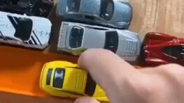 Cet homme teste les capacités des voitures de sport miniatures sur un circuit