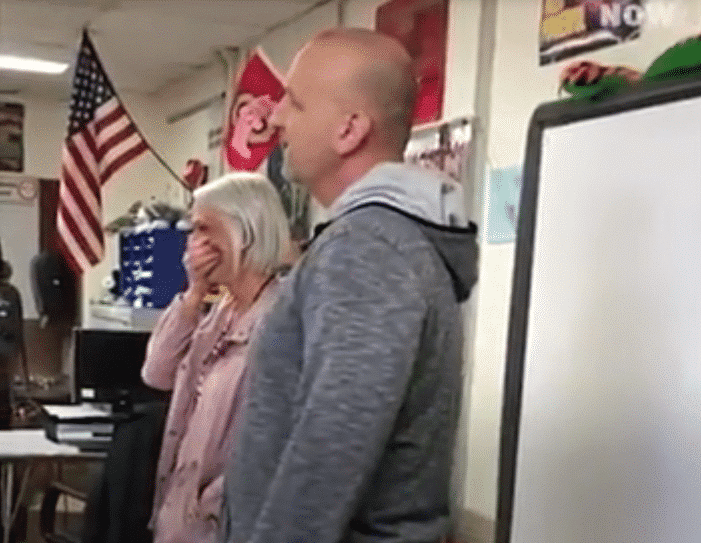 Un professeur de Science fait sa demande à une enseignante dans la salle de classe devant les élèves