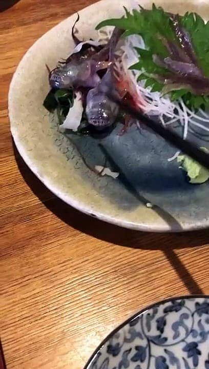 Un poisson bouge encore et agrippe les baguettes de ce restaurant japonais
